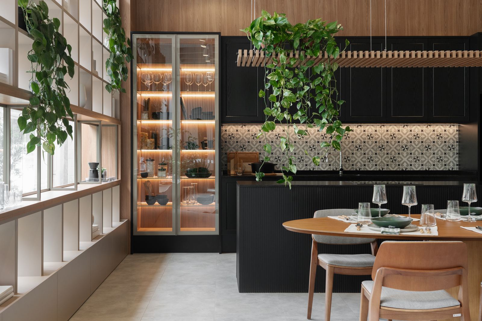 Cozinha planejada preta integrada à sala de jantar com plantas, projeto Domus Italínea
